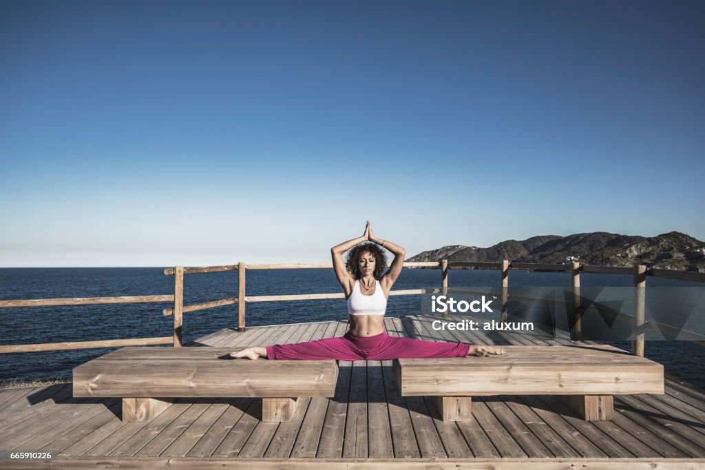 Woman doing exercises outdoors Young woman exercising and doing split outdoors at the sea Doing the Splits Stock Photo