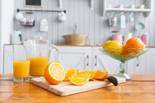 sliced oranges on a wooden cutting board. healthy and tasty breakfast - freshly squeezed orange juice imagens e fotografias de stock