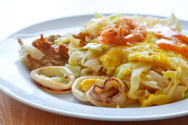 istock stir fried large noodle seafood and egg dressing chili sauce 665914398