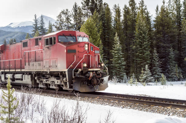 istock Huge Red Locomotive in Motion with Trees in Background 665941248