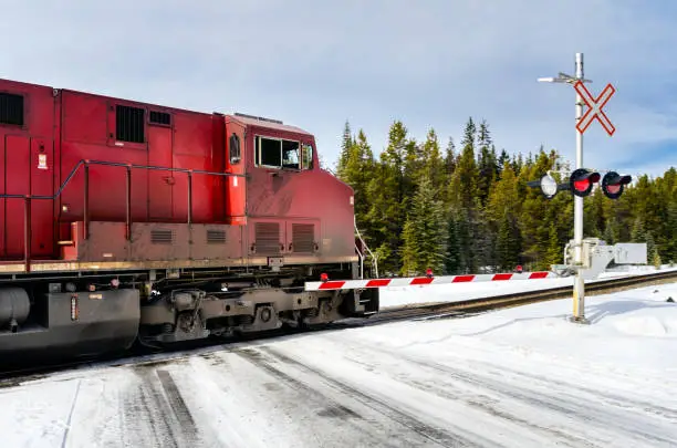 Photo of Train in Motion at a Level Crossing on a Cloudy Winter Day