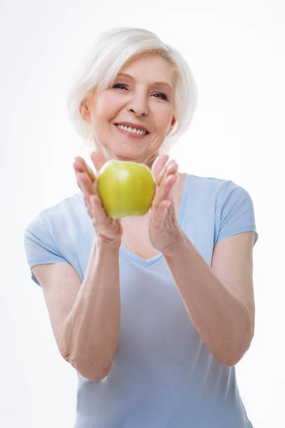 istock Happy smiling woman keeping apple in both hands 665945450