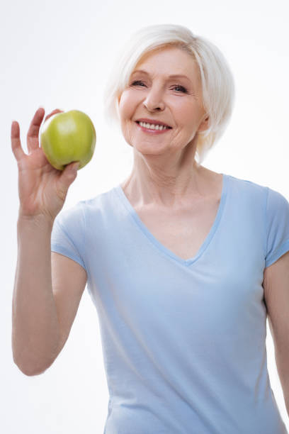 istock Healthy positive elderly lady posing with apple 665945582