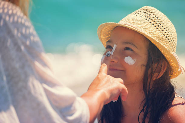 istock Young Mother Applying Suntan Lotion On Daughter's Face 665946478