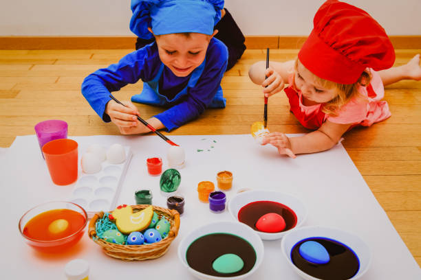 istock little boy and girl painting eggs for easter 665947272