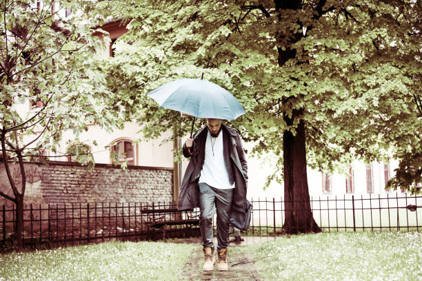 istock Business man running  with umbrella on rainy day. 665947292