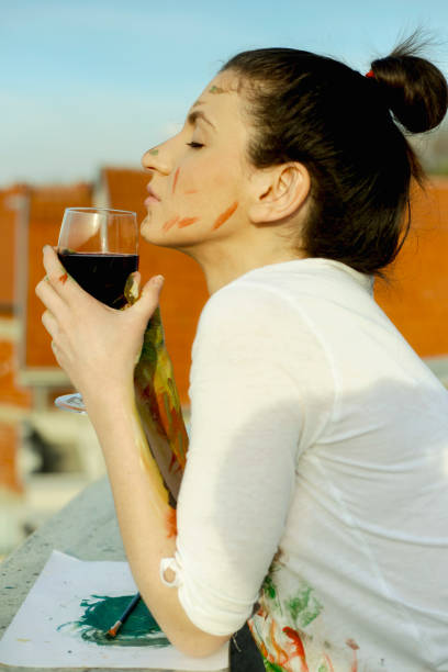 istock Young artistic woman with red wine in hands 665949700