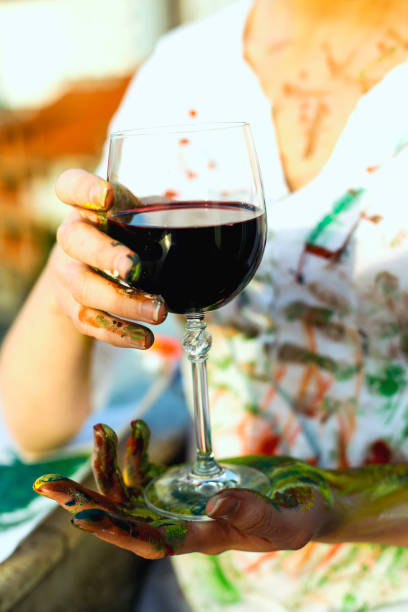 istock Young artistic woman with red wine in hands 665953052