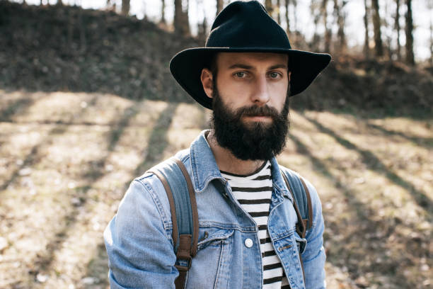 istock bearded man in a hat and denim jacket in the woods 665953076