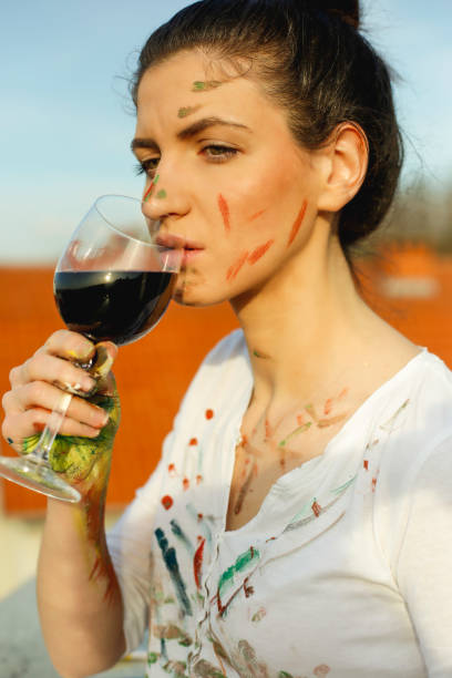 istock Young artistic woman with red wine in hands 665953114