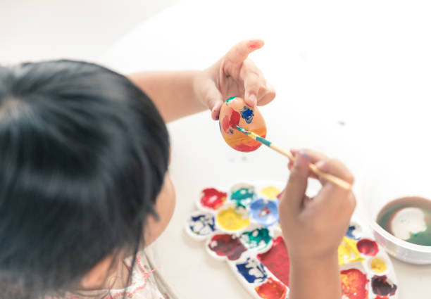 Asian child painting on Easter egg