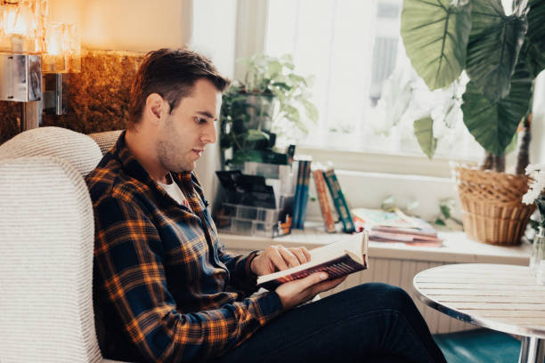 istock Man in the cafe is reading a book 665972252