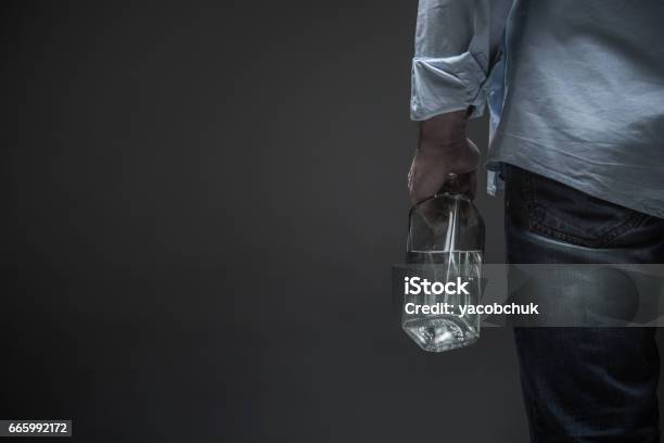 Photo Of Male Back Holding Bottle In Hand Stock Photo - Download Image Now - Alcohol Abuse, Alcohol - Drink, Drunk