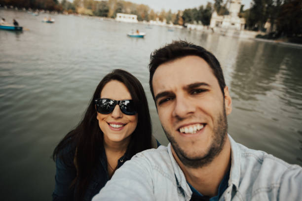 istock Smiling couple taking a selfie with lake in the background 666012500