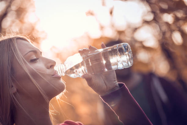 istock Man and women resting and drinking water after jogging in park 666021164