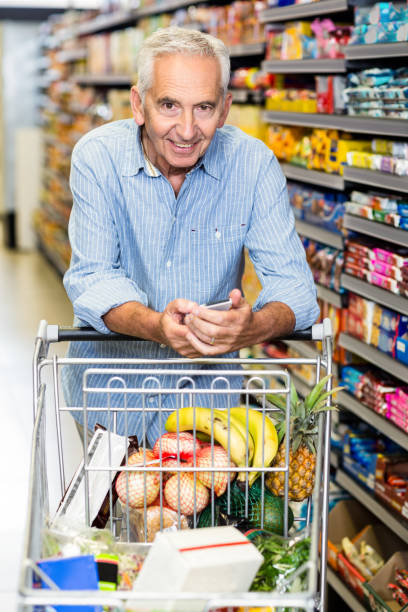 istock Senior man using phone at grocery store 666030032