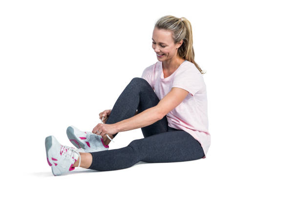 istock Sporty woman smiling while tying shoelace 666030948