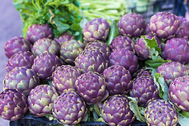 artichauts sur un marché - purple artichoke photos et images de collection