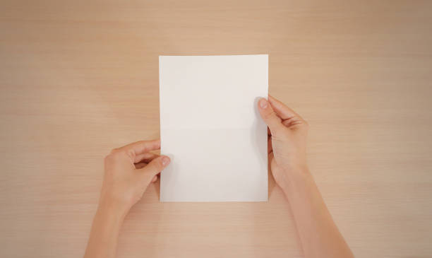 istock Hands holding blank white brochure booklet in the hand. Leaflet presentation. Pamphlet hand man. Show offset paper. Sheet template. Book in hands. Booklet folding design. Fold paper sheet display read 666036414