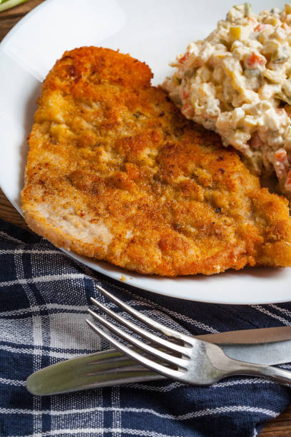 istock Fried pork chop in breadcrumbs, served with vegetable salad. 666043700
