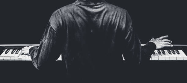 istock back of male musician playing piano 666053244