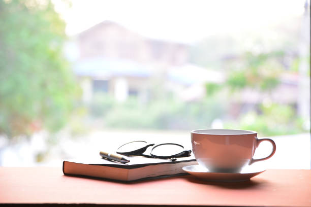istock Coffee cup with book, pen and glasses 666053950