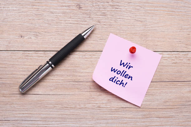 istock Wir wollen dich german words for we want you on pink sticky note 666054544