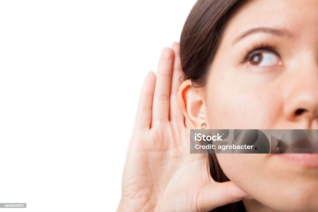 Woman holds her hand near ear and listens carefully Ear Stock Photo