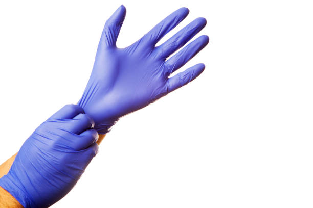 médico poner guantes de protección azul aislados en blanco - guante quirúrgico fotografías e imágenes de stock