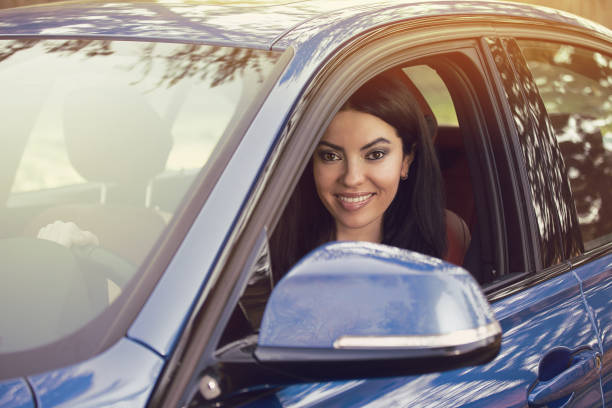 istock attractive young woman sitting inside her car 666065128