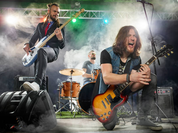 istock Rock band performs on stage. Guitarist, bass guitar and drums. 666066466
