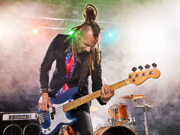 istock Rock band performs on stage. Bassist in the foreground. 666066524