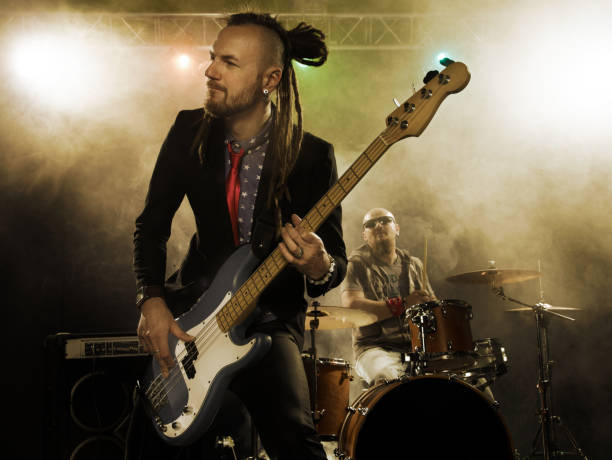 istock Rock band performs on stage. Bassist in the foreground. 666066536