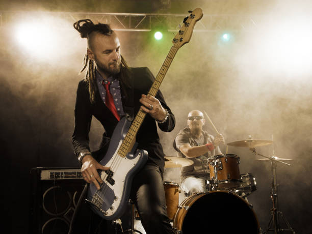 istock Rock band performs on stage. Bassist in the foreground. 666066554
