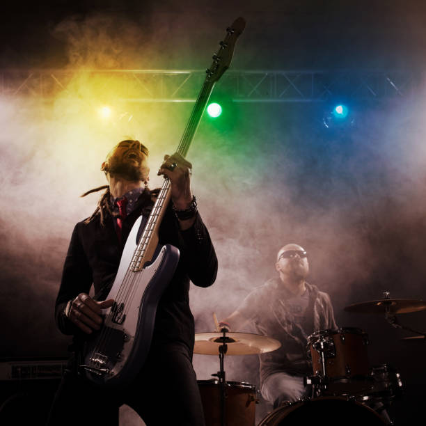 istock Rock band performs on stage. Bassist in the foreground. 666066556