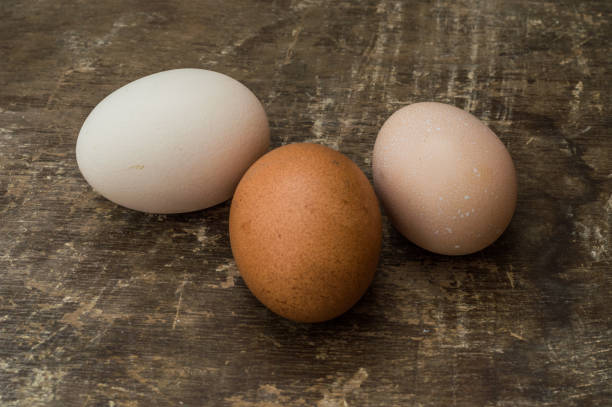istock Three fresh chicken eggs on an old wooden background 666072416