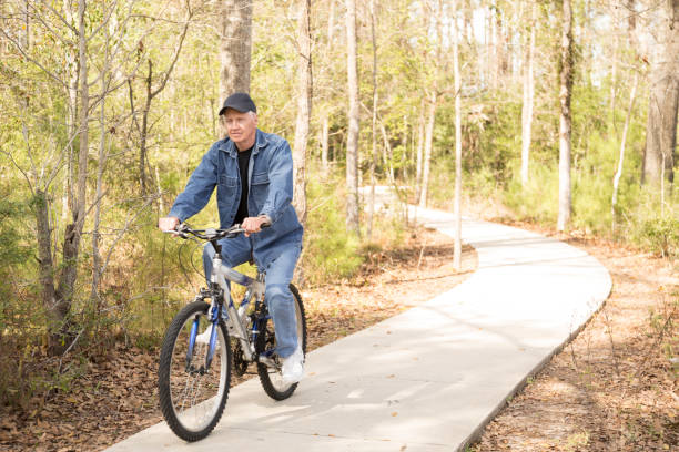 istock Active senior adult man biking in park. 666088532