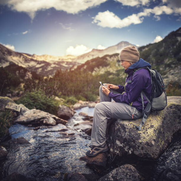 istock Traveler using a smartphone in the mountains 666094748