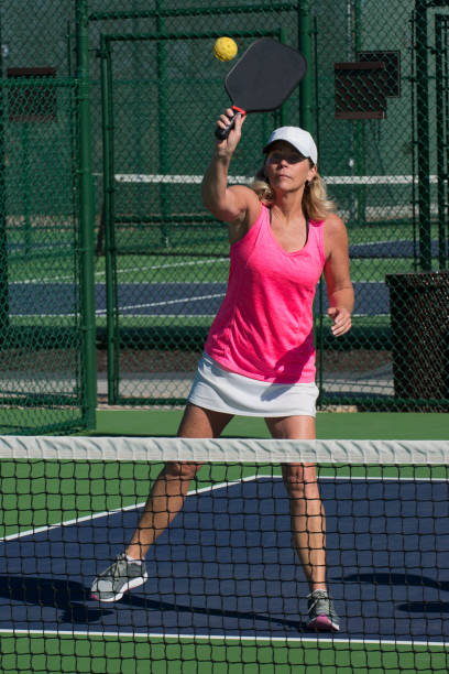 istock Pickleball - Female Player Hitting Overhead Shot at Net 666102356