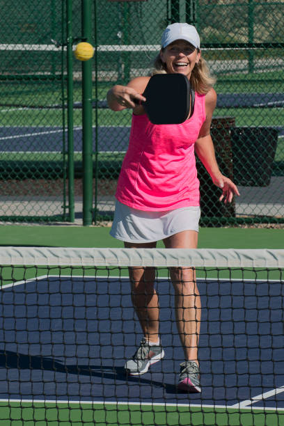istock Pickleball - Female Player Hitting a Backhand Shot at the Net 666105338