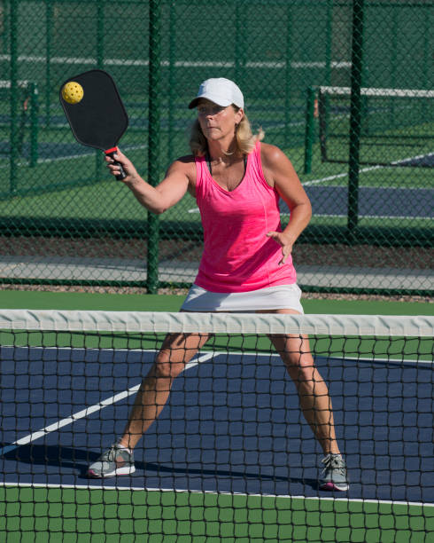 istock Pickleball - Female Player Hitting Forehand Shot at Net 666108556