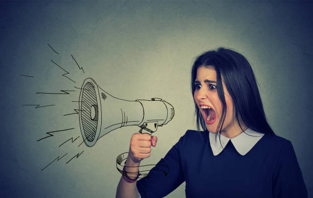 istock Angry young woman screaming in megaphone 666119790
