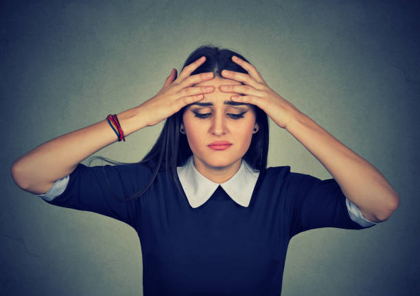 istock Young worried woman has headache isolated on a gray background 666122162