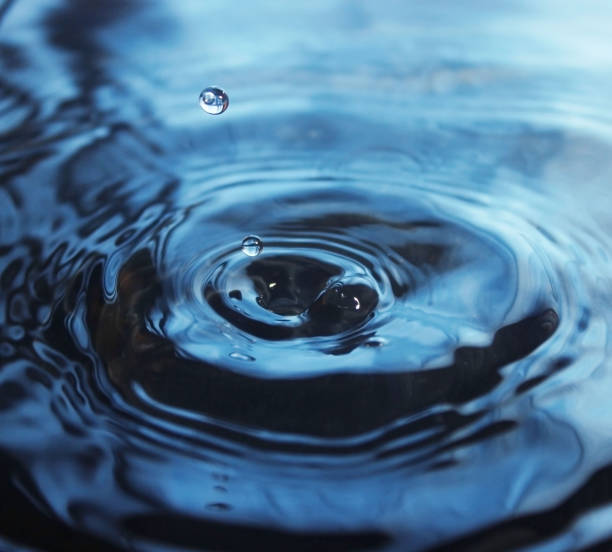 Water Drop impact on water surface stock photo