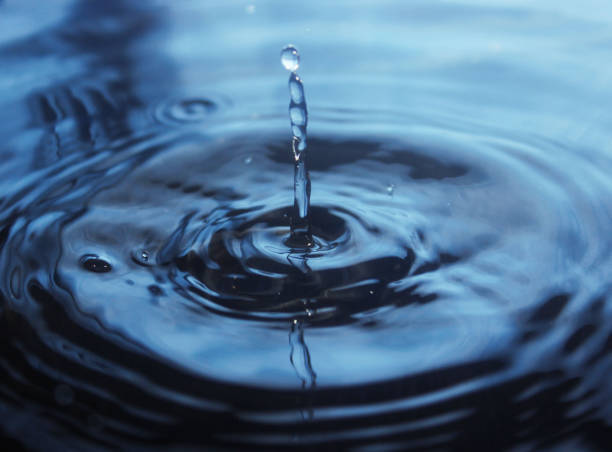 Beautiful splash of water drop on water surface stock photo