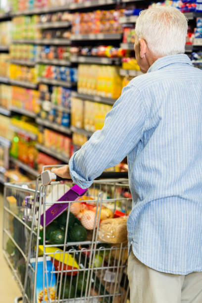 istock Rear view of senior man pushing trolley 666126130