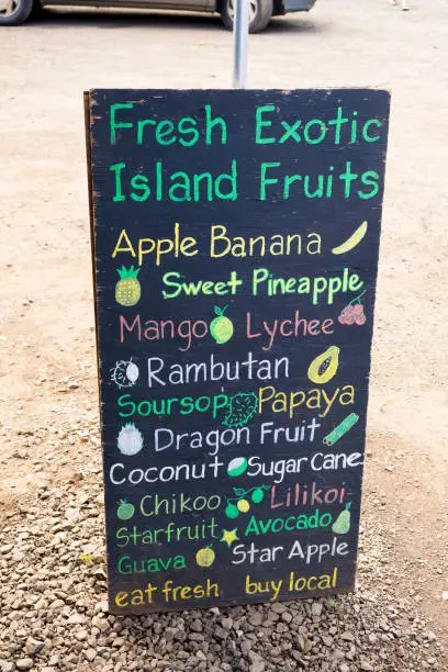 Sign for a farmers market on the North Shore of Oahu Hawaii lists every type of tropical fruit they have for sale.