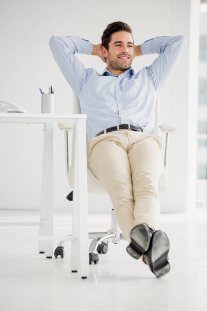 istock Businessman sitting with hands behind head in the office 666128924