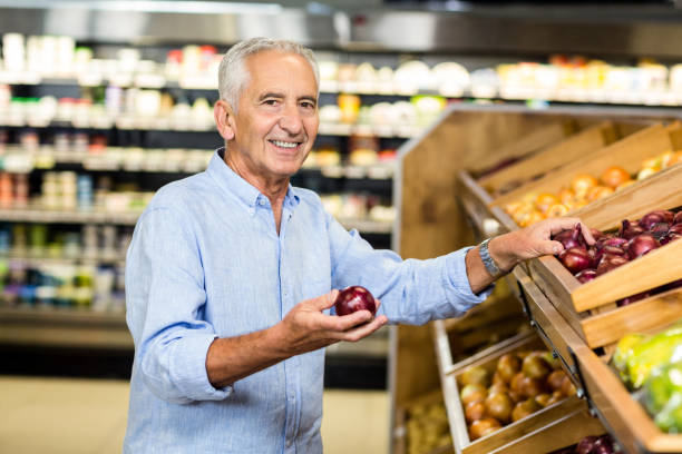 istock Smiling senior man holding red onion 666135072