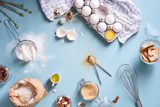 istock Bakery ingredients - flour, eggs, butter, sugar, yolk, almond nuts on blue table. Sweet pastry baking. 666155998